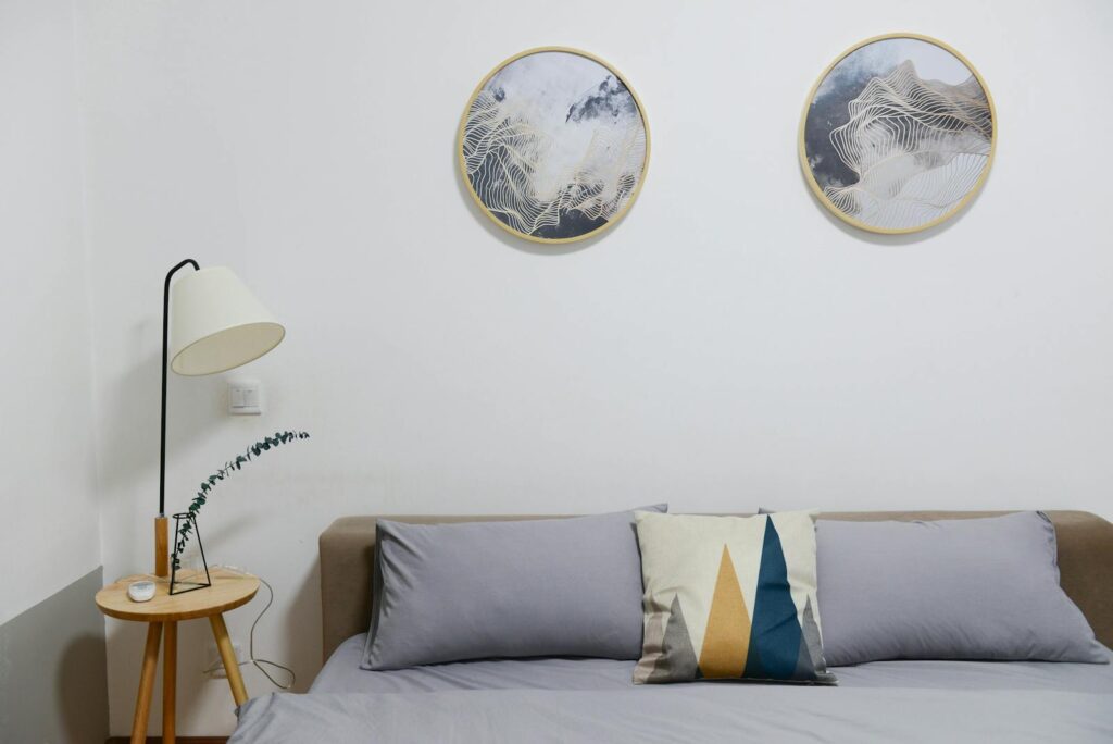 Stylish modern bedroom featuring minimalist decor with abstract wall art and cozy furniture.