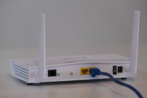 Broadband internet router with ethernet cable plugged in to the back in the ethernet port.