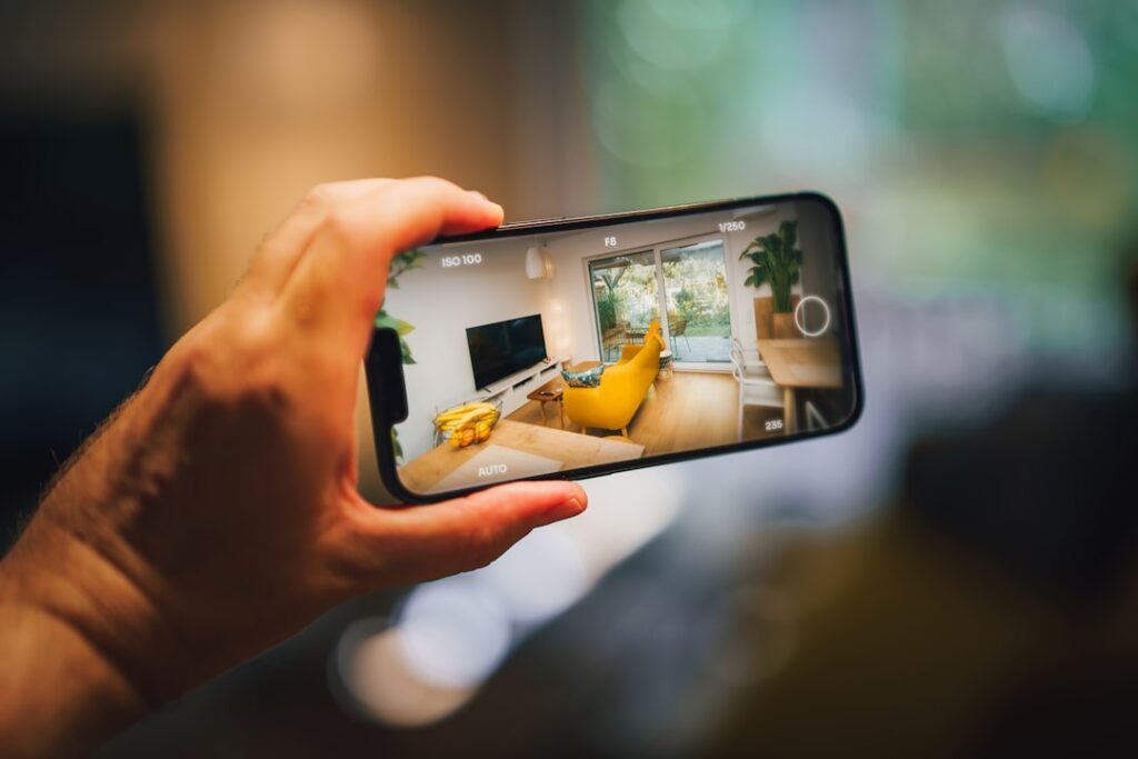 Real estate virtual tour mobile photo camera app. Hand holding smartphone. Home interior.