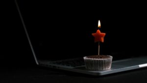 a burning birthday candle on a chocolate cake