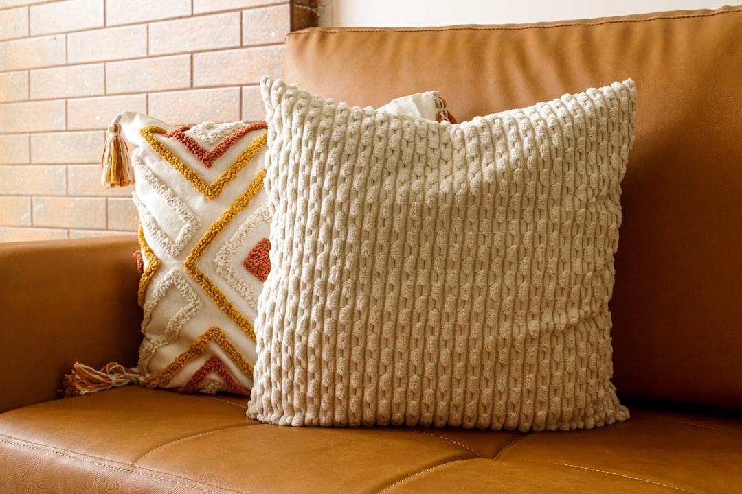 Stylish, well-lit living room with cozy borro decor and a caramel synthetic sofa. Modern comfort and ambiance.