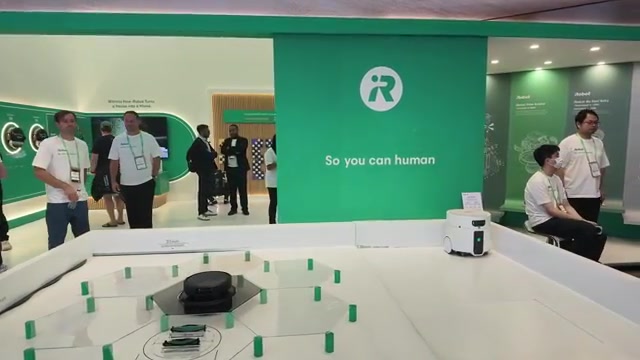Beursstand van iRobot op de IFA met een robotstofzuiger op een parcours